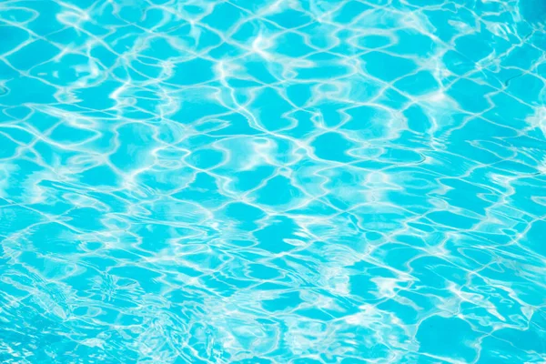 Mavi yüzme havuzunun arka planındaki sudan yansımalar.