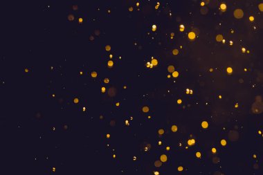 Siyah arkaplanda koyu soyut altın bokeh parıltısı
