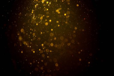 Siyah arkaplanda koyu soyut altın bokeh parıltısı
