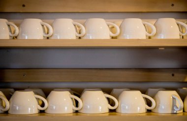 Raflara seramik kahve fincanları yerleştirildi.