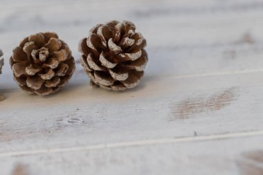 Beyaz, eski ahşap arka planda kurumuş çam topları.