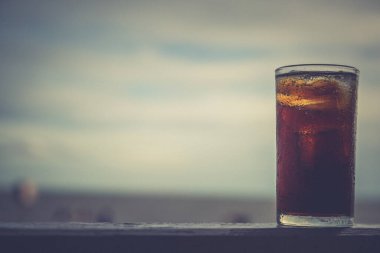 Buzlu kola, arka planda tazelenmek üzere içilmeye hazır.