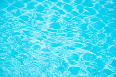 Mavi yüzme havuzunun arka planındaki sudan yansımalar.