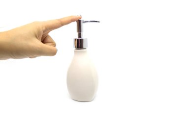 Beyaz arka planda bir şişe sıvı sabun tutan kadın.