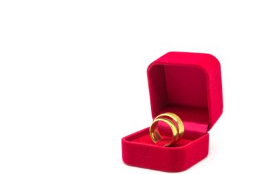 Beyaz arka planda kırmızı kadife kutuda alyans