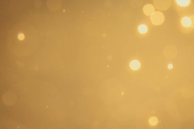 Siyah arkaplanda koyu soyut altın bokeh parıltısı