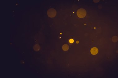 Siyah arkaplanda koyu soyut altın bokeh parıltısı