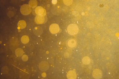 Siyah arkaplanda koyu soyut altın bokeh parıltısı