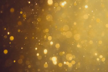 Siyah arkaplanda koyu soyut altın bokeh parıltısı