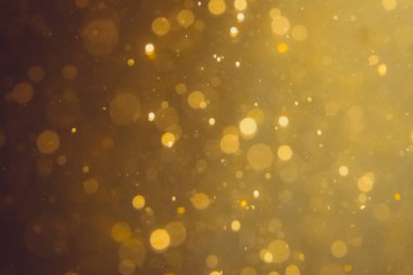 Siyah arkaplanda koyu soyut altın bokeh parıltısı