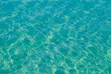 Güneşi yansıtan mavi havuz suyu