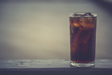 Buzlu kola, arka planda tazelenmek üzere içilmeye hazır.