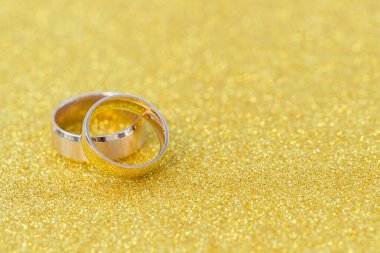 Gelinin ve damadın altın alyansları altın kaplama arka planda