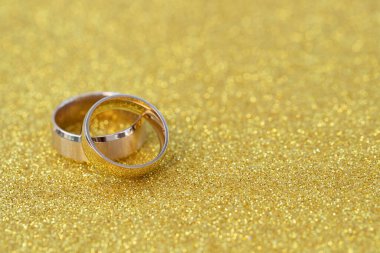 Altın yüzükler, gelin ve damadın alyansları beyaz, eski ahşap arka planda.