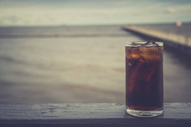 Buzlu kola, arka planda tazelenmek üzere içilmeye hazır.