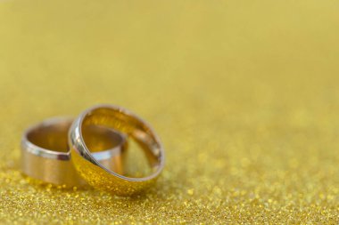Gelinin ve damadın altın alyansları altın kaplama arka planda