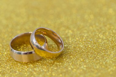 Gelinin ve damadın altın alyansları altın kaplama arka planda