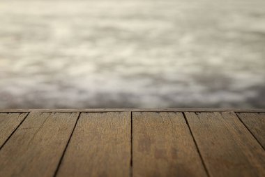 Ahşap zemin, günbatımı arka planında su düştüğünde denize doğru uzanıyor.