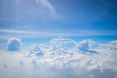 Gökyüzü ve yerden görünen bulutlar, açık renkli arka planlı bir uçaktan görüldü.