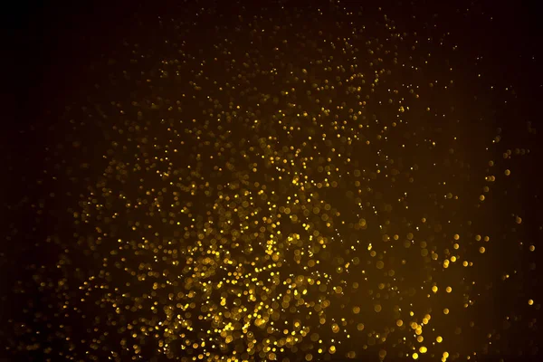 Siyah arkaplanda koyu soyut altın bokeh parıltısı