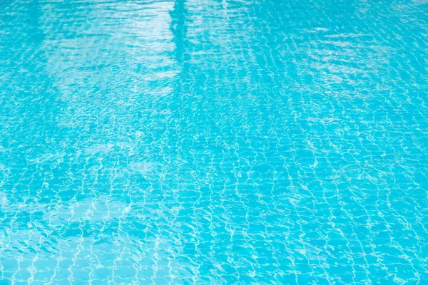 Mavi yüzme havuzunun arka planındaki sudan yansımalar.