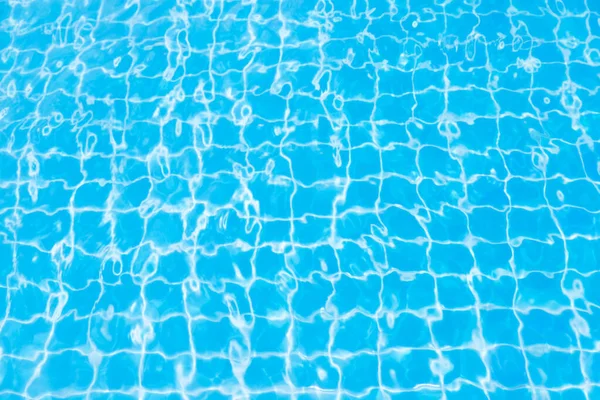 Mavi yüzme havuzunun arka planındaki sudan yansımalar.