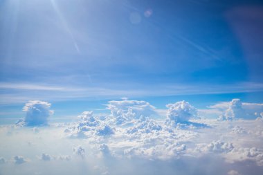 Gökyüzü ve yerden görünen bulutlar, açık renkli arka planlı bir uçaktan görüldü.