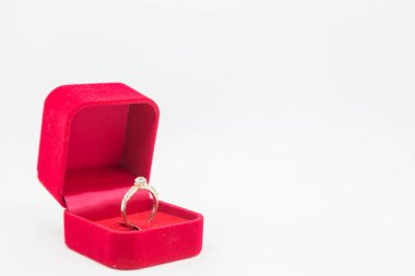 Beyaz arka planda kırmızı kadife kutuda alyans