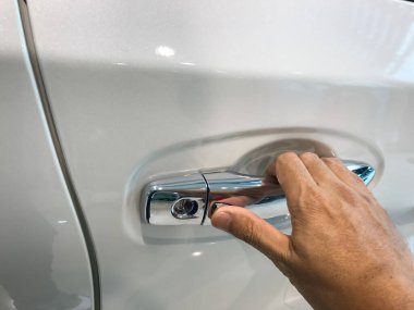 Adamın eli arabanın arka kapısını açıyor.