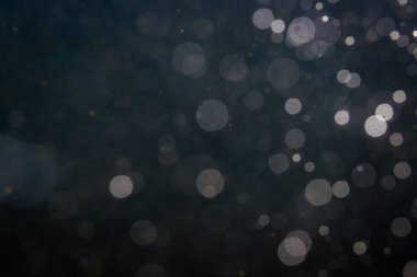 Fantezi bokeh siyah arkaplanda ışıktan parıldıyor