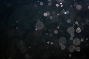 Fantezi bokeh siyah arkaplanda ışıktan parıldıyor