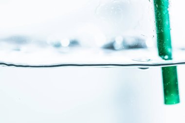 Su altı mavi kabarcıkları yeşil tüpler arka planda