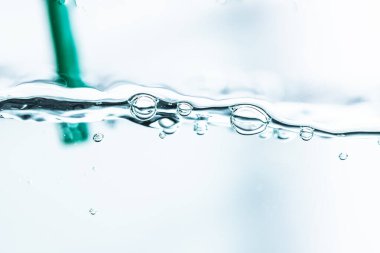 Su altı mavi kabarcıkları yeşil tüpler arka planda