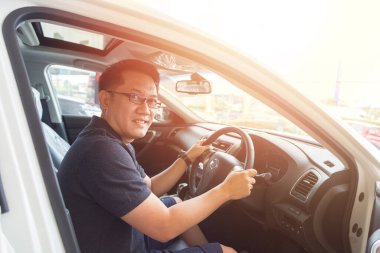 Yakışıklı Asyalı adam mutlu bir araba kullanmayı seviyor.