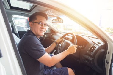 Yakışıklı Asyalı adam mutlu bir araba kullanmayı seviyor.