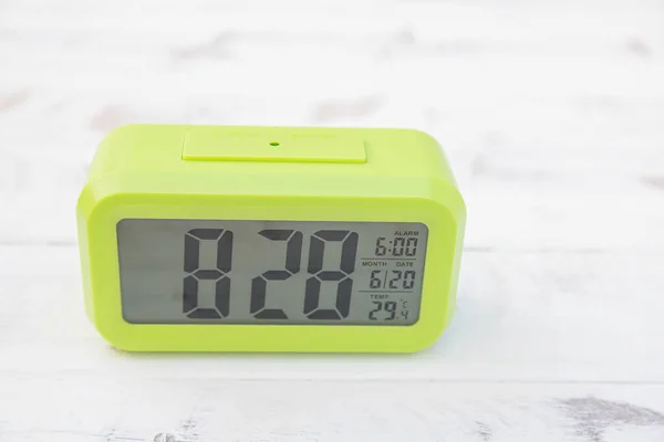 Light green digital clock on vintage wooden panels