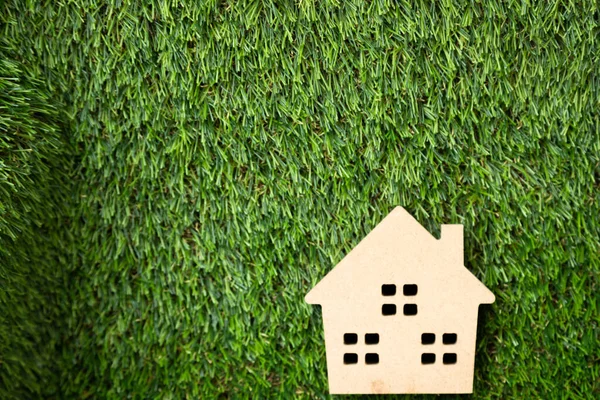 Yapay çimlerin üzerinde küçük ahşap bir ev.