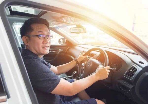 Yakışıklı Asyalı adam mutlu bir araba kullanmayı seviyor.
