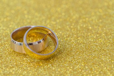 Gelinin ve damadın altın alyansları altın kaplama arka planda