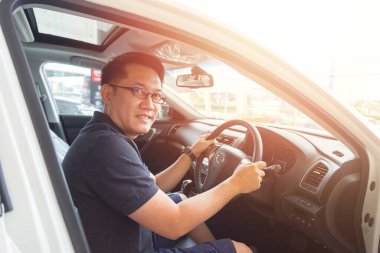 Yakışıklı Asyalı adam mutlu bir araba kullanmayı seviyor.