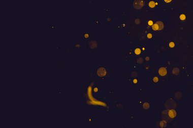 Siyah arkaplanda koyu soyut altın bokeh parıltısı