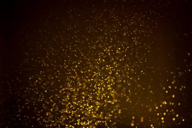 Siyah arkaplanda koyu soyut altın bokeh parıltısı