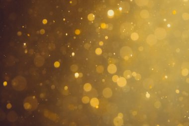 Siyah arkaplanda koyu soyut altın bokeh parıltısı