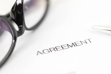 Sign on contract document with fountain pen and glasses on white background