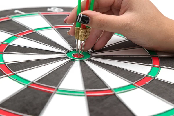 Hands with darts at the target center on a white background