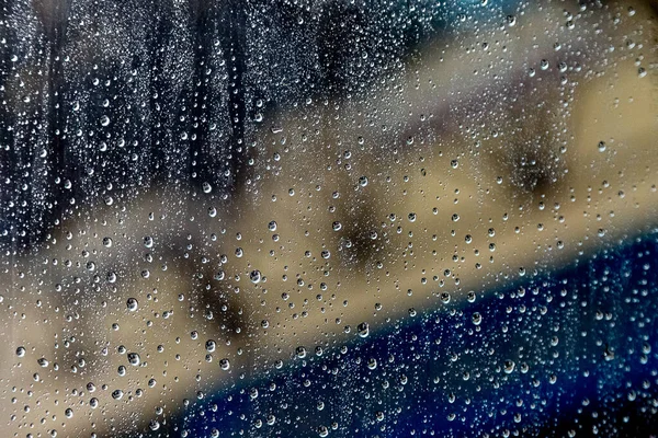 背景がぼやけてフロントガラスに雨が降ります — ストック写真