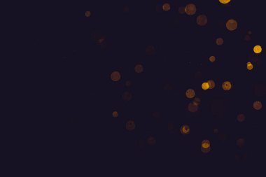 Fantezi altın bokeh siyah arkaplanda ışıktan parıldıyor