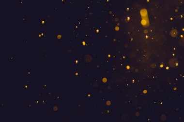 Siyah arkaplanda koyu soyut altın bokeh parıltısı