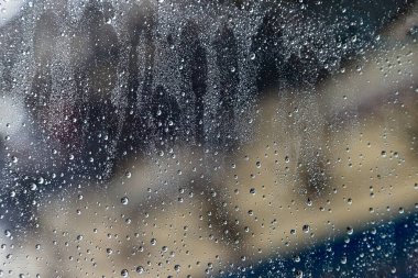 Arka planda bulanık olan yağmur damlaları ön camda