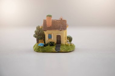 Kiremitli çatı altında sarıya boyanmış ev modeli bulanık doğal arka planda izole edilmiş..